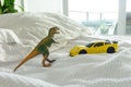 Toy dinosaur and car on parent`s bed
