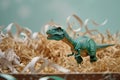 toy dinosaur standing in bed of paper shred gift box