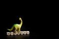 Toy dinosaur stands on cubes with the inscription toriya. The concept of studying history, the Mesozoic era and ancient reptiles.