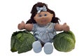 Toy doll sitting between two cabbages