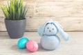 Toy Easter bunny and painted eggs on a wooden background