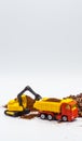 A toy excavator loads coffee beans into the back of a toy truck with a bucket, and a toy bulldozer rakes roasted coffee beans into Royalty Free Stock Photo