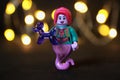 Toy female genie figure with red hair and lips holding a purple balloon animal