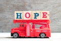 Toy fire ladder truck hold block in word hope on wood background Royalty Free Stock Photo