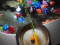 A toy fishing rod hangs over a miniature pool with plastic colorful fish. Child Game Royalty Free Stock Photo
