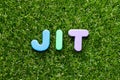 Toy letter in word JIT abbreviation of just in time on green grass background