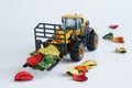 Toy forklift cleaning colorful dry fallen autumn leaves. Concept of autumn cleaning and landscaping. Concept of an educational
