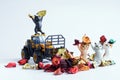 Toy forklift with funny kittens is cleaning colorful dry fallen autumn leaves. Concept of autumn cleaning and landscaping. Concept