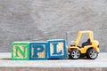 Toy forklift hold letter block L to complete word NPL abbreviation of Non Performing Loan, Non-Patent Literature on wood