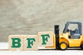 Toy forklift hold block f to complete word BFF Abbreviation of best friend forever on wood background