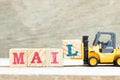 Toy forklift hold block l to complete word mail on wood background