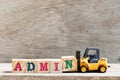 Toy forklift hold letter N in word admin on wood background