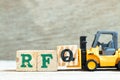 Toy forklift hold block Q to complete word RFQ abbreviation of request for quotation on wood background Royalty Free Stock Photo