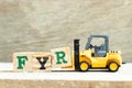 Toy forklift letter block R to complete word FYR abbreviation of for your reference on wood background Royalty Free Stock Photo