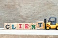 Toy forklift hold block t to complete word client on wood background Royalty Free Stock Photo