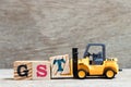 Toy forklift hold letter block T to word GST abbreviation of Goods and Services Tax on wood background Royalty Free Stock Photo