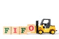 Toy forklift hold letter block to word FIFO Abbreviation of first in first out on white background Royalty Free Stock Photo