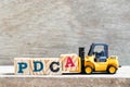 Toy forklift hold letter block A to complete word PDCA Plan, Do, Check, Act Royalty Free Stock Photo