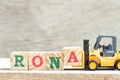 Toy forklift hold block a to complete word RONA Abbreviation of Return on net assets on wood background