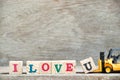 Toy forklift hold letter block u to complete word I love u on wood background & x28;Concept for Valentine& x27;s day Royalty Free Stock Photo