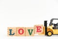 Toy forklift hold wood letter block E to word love on white background Royalty Free Stock Photo
