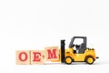 Toy forklift hold wood letter block M to complete word OEM Abbbreviation of Original Equipment Manufacturer on white background Royalty Free Stock Photo