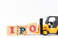 Toy forklift hold wood block O to complete word IPO Abbreviation of Initial Public Offering on white background Royalty Free Stock Photo