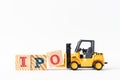 Toy forklift hold wood block O to complete word  IPO Abbreviation of Initial Public Offering on white background Royalty Free Stock Photo