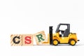 Toy forklift hold wood letter block R to word CSR Abbreviation of corporate social responsibility on white background Royalty Free Stock Photo