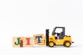 Toy forklift hold wood block T to complete word JIT Abbreviation of Just in time on white background