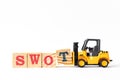 Toy forklift hold wood block t to complete word swot abbreviation of strength, weakness, opportunities, threats on white Royalty Free Stock Photo