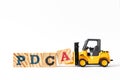 Toy forklift hold wood block a to complete word PDCA Plan, Do, Check, Act on white background Royalty Free Stock Photo