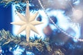 Toy in the form of a large star hanging on the Christmas tree. White eight pointed star on fir