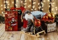 Toy in the form of Santa Claus on a sled. Against the background of bright Christmas gifts and lights. Royalty Free Stock Photo