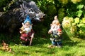 Toy garden gnomes and a wild boar on a blurred background of