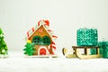 A toy ginger house next to a sleigh full of Christmas gifts. New year card and holiday design with copy space Royalty Free Stock Photo