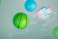 Toy green ball and many toy floating in inflatable pool