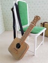 Toy guitar hanging on a doll chair