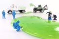 A toy hazmat crew cleans up green slime on a white background.