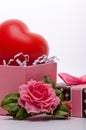 Toy heart in an open pink cardboard box with a bow of pink ribbon and jewelry in the form of a rose, a gift to the girl Royalty Free Stock Photo