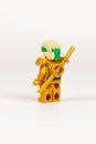 Toy hero Lloyd in a gold kimono with a sword from a set of lego ninjago on a white background. close-up Royalty Free Stock Photo