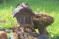 A toy homemade house of a fairy-tale creature made of logs and branches in the park