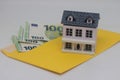 Toy house. banknotes in a yellow envelope on a light background. envelope with banknotes. close-up of an envelope with