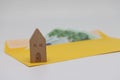 Toy house. banknotes in a yellow envelope. open envelope with banknotes on a light background. envelope with banknotes