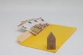 Toy house. banknotes in a yellow envelope. open envelope with banknotes on a light background. envelope with banknotes