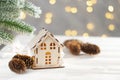 Toy house and christmas tree with fir cones, abstract light white natural holiday background with copy space Royalty Free Stock Photo