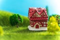 A toy house on green grass in fictional world