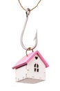 Toy house on a hook Isolated on a white background. Mortgage and tax payment concept Royalty Free Stock Photo