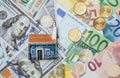 Toy house on many euro and dollar banknotes and euro coins Royalty Free Stock Photo