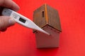 Toy house, thermometer on red color.  Home quarantine concept Royalty Free Stock Photo